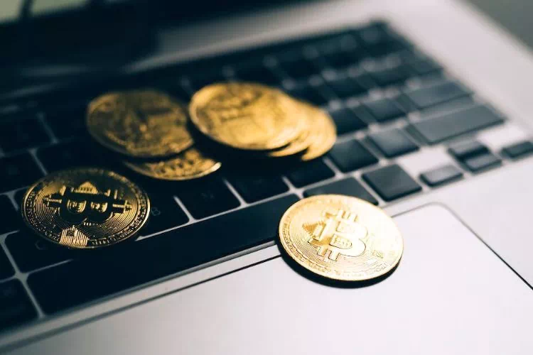 Des pièces de Bitcoin sur le clavier d'un ordinateur