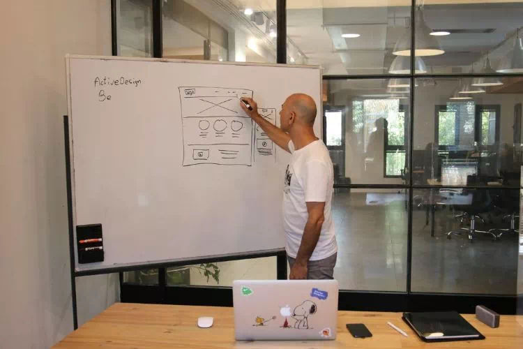 UX designer faisant un schéma sur un white board