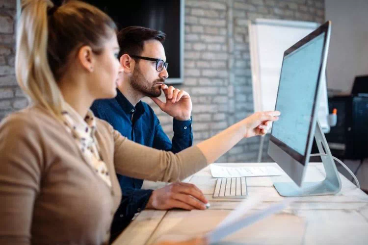 Deux consultants travaillant ensemble sur un ordinateur