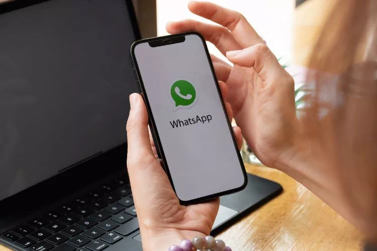 Femme sur son téléphone avec l'application WhatsApp ouverte