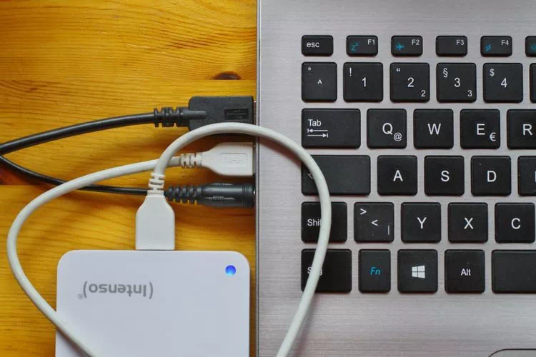 Disque dur externe blanc branché à un ordinateur
