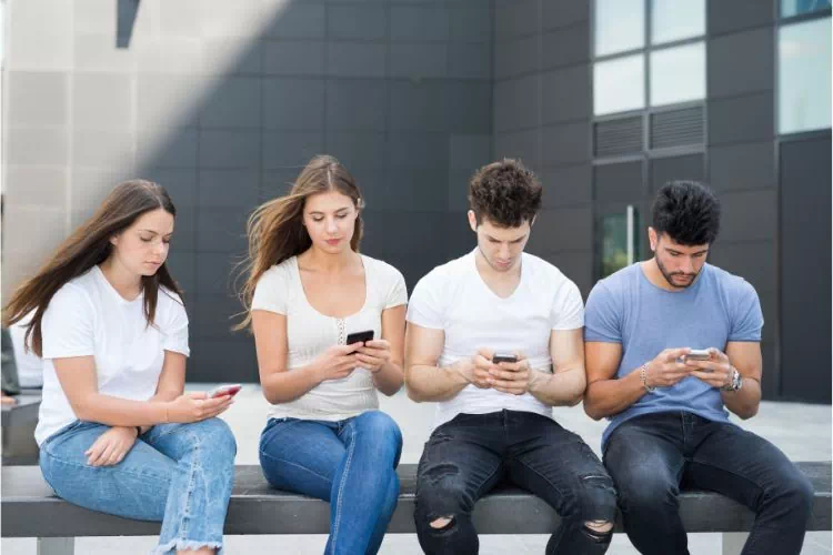 Groupe de 4 jeunes ayant une dépendance à leur smartphone