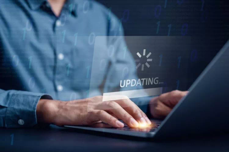 Homme sur son ordinateur en train de faire une mise à jour de son site internet