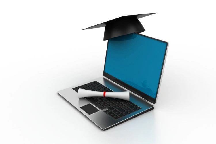 Chapeau de diplômé posé sur un ordinateur représentant un diplôme universitaire en communication
