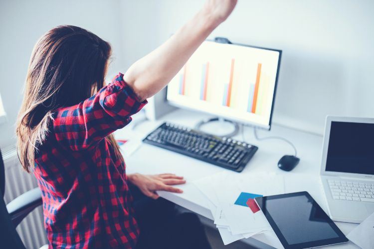 Femme heureuse devant son ordinateur pour une campagne publicitaire réussie avec google grants