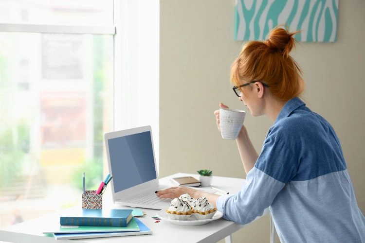 Femme sereine devant son ordinateur qui évite d'être victime de revenge porn