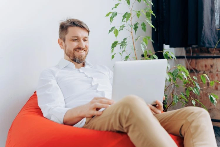 Homme heureux devant son ordinateur parce qu'il évite la cyberviolence