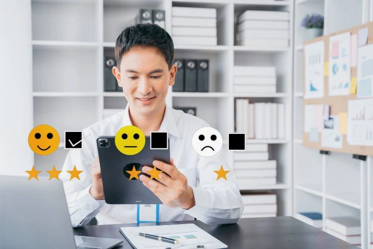 Homme avec sa tablette et des têtes d'émojis d'humeur pour représenter l'interaction entre le client et l'entreprise