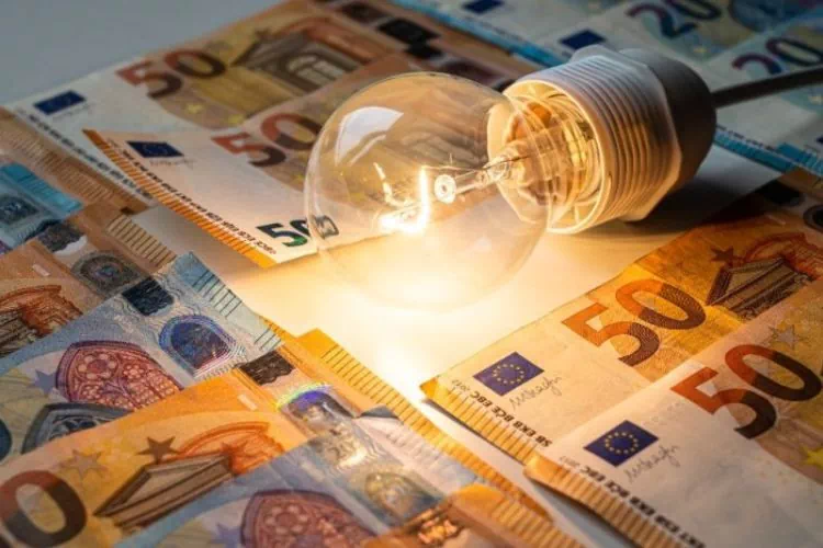 Ampoule électrique posée sur des billets : prix de l'électricité