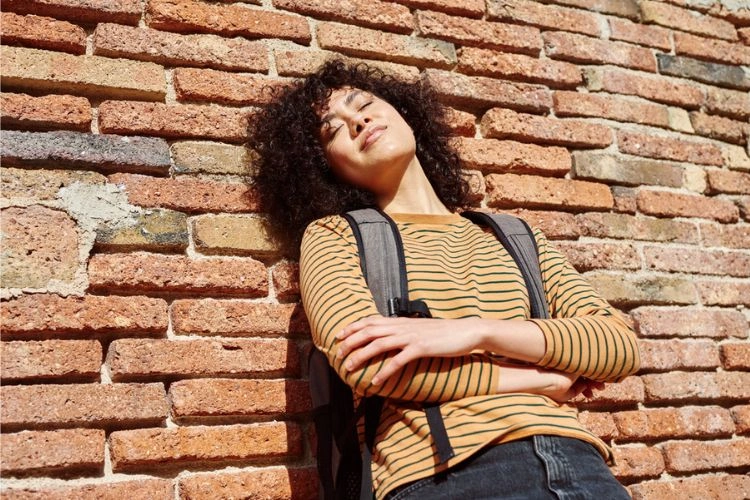 Photo d'une femme près d'un mur rugueux